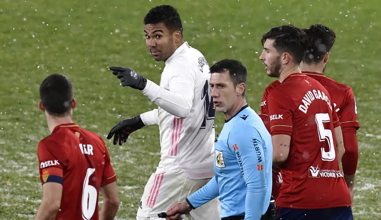 Gelandang Real Madrid, Casemiro, bersitegang dengan pemain Osasuna, Oier, pada laga Liga Spanyol di Stadion El Sadar, Sabtu (9/1/2021). Kedua tim bermain imbang 0-0. (AP/Alvaro Barrientos)