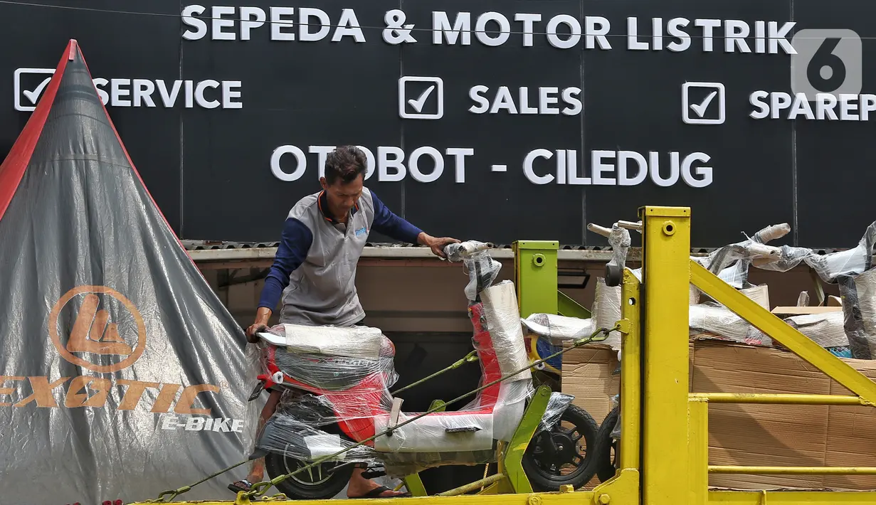 Pekerja tengah menurunkan sepeda motor listrik yang akan di jual di shorum di Tangerang, Banten, Kamis (27/7/2023). (Liputan6.com/Angga Yuniar)
