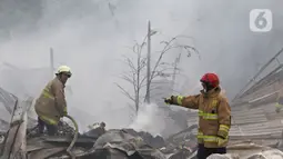 Petugas pemadam kebakaran melakukan pendingin di Pabrik penggilingan kapas,  Pasar Rebo, Jakarta Timur, Selasa (16/11/2021). Sudin Penanggulangan Kebakaran dan Penyelamatan (Gulkarmat) Jakarta Timur menurunkan 13  mobil pemadam kebakaran  untuk memadamkan api. (Liputan6.com/Herman Zakharia)