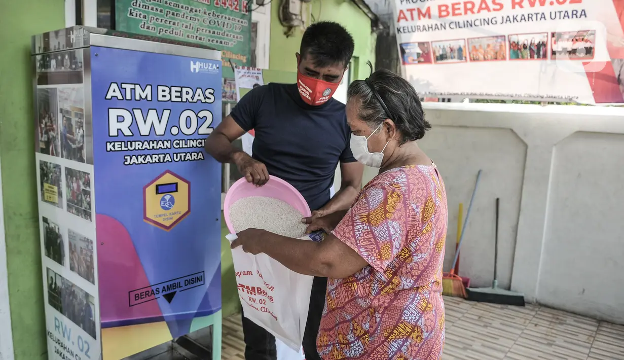 Warga saat memasukkan beras menggunakan kantong ramah lingkungan di Kantor RW 02, Kelurahan Cilincing, Jakarta Utara, Rabu (17/3/2021). Warga di RW 02 Kelurahan Cilincing membuat ATM Beras secara mandiri yang kemudian dibagikan kepada lansia dan masyarakat tidak mampu. (merdeka.com/Iqbal S. Nugroho)