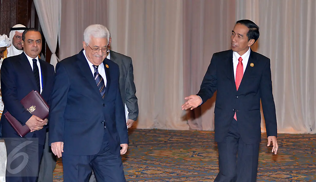 Presiden Palestina Mahmoud Abbas tersenyum ketika berbincang dengan Presiden RI, Jokowi (kanan) sesaat sebelum foto bersama peserta KTT Luar Biasa Organisasi Kerja sama Islam (OKI) di Jakarta Convention Center, Senin (7/3). (Liputan6.com/Faizal Fanani)
