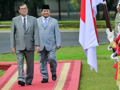 Presiden Republik Indonesia, Prabowo Subianto (kedua dari kiri) bersama Perdana Menteri Jepang Shigeru Ishiba memeriksa pasukan pengawal kehormatan di Istana Kepresidenan di Bogor, Jawa Barat, pada Sabtu 11 Januari 2025. (Bay ISMOYO/AFP)