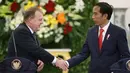 Presiden Jokowi dan PM Denmark Lars Lokke Rasmussen berjabat tangan seusai pernyataan bersama kedua negara di Istana Bogor, Selasa (28/11). Jokowi mendapatkan cenderamata dari PM Denmark berupa album piringan hitam band Metallica. (AP/Dita Alangkara)