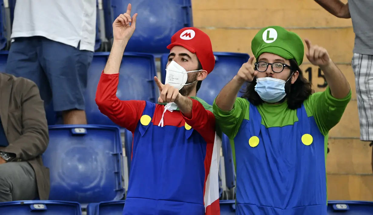 Suporter timnas Italia mengenakan kostum saat menyaksikan laga Grup A Euro 2020 antara Italia dan Swiss di stadion Olimpiade di Roma, Rabu (16/6/2021). Dalam laga tersebut, Timnas Italia menghajar Swiss dengan skor 3-0. (Andreas Solaro/Pool Photo via AP)