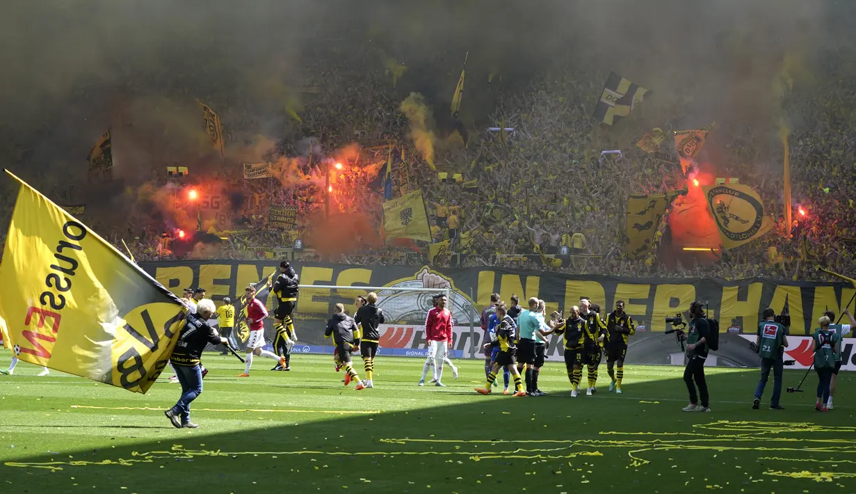 Para suporter menyalakan flare sebelum dimulainya laga pekan terakhir terakhir Liga Jerman 2022/2023 antara Borussia Dortmund menghadapi FSV Mainz di Dortmund, Jerman (27/5/2023). (AP Photo/Michael Probst)