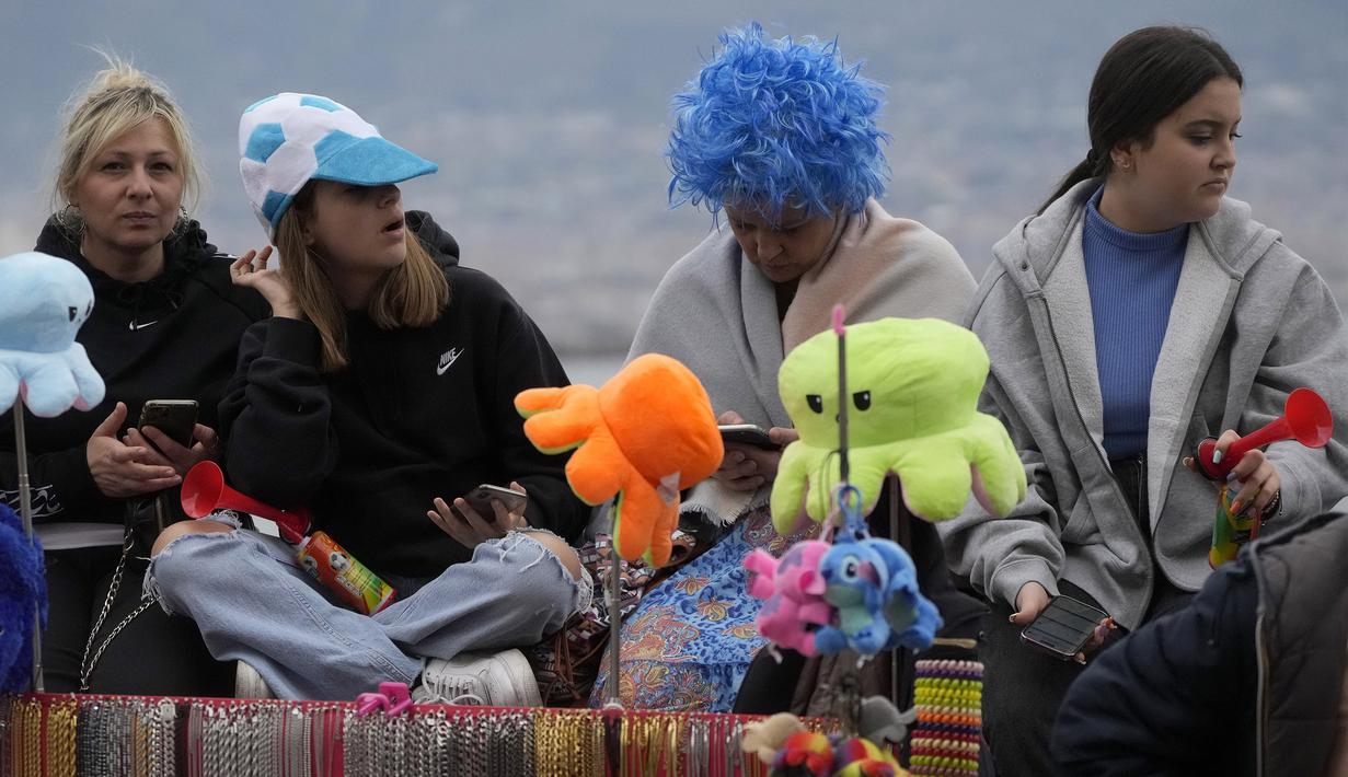 Sejumlah fans Napoli yang tidak dapat menonton langsung di Stadion Diego Armando Maradona hanya bisa melihat info pertandingan dari gawai. (AP Photo/Gregorio Borgia)