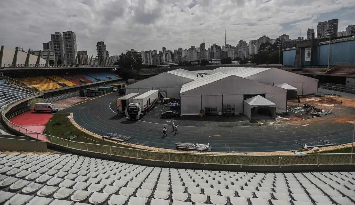 Orang-orang bekerja di lokasi pembangunan rumah sakit sementara di kompleks olahraga Ibirapuera di tengah merebaknya COVID-19 di Sao Paulo (16/4/2020). Jumlah kasus terkonfirmasi COVID-19 di Brasil melonjak dari 28.320 menjadi 30.425, kata Kemenkes Brasil pada Kamis (16/4). (Xinhua/Rahel Patrasso)