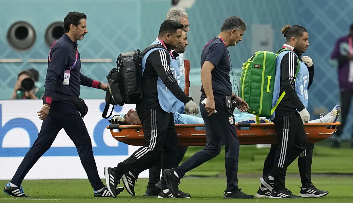 Paramedis membawa Alireza Beiranvand dengan tandu setelah kiper timnas Iran tersebut cedera saat pertandingan sepak bola grup B Piala Dunia Qatar 2022 antara Inggris dan Iran di Stadion Internasional Khalifa, Doha, Qatar, Senin (21/11/2022). Pertandingan kembali berlanjut dengan kiper cadangan, Seyed Hossein Hosseini. (AP Photo/Abbie Parr)