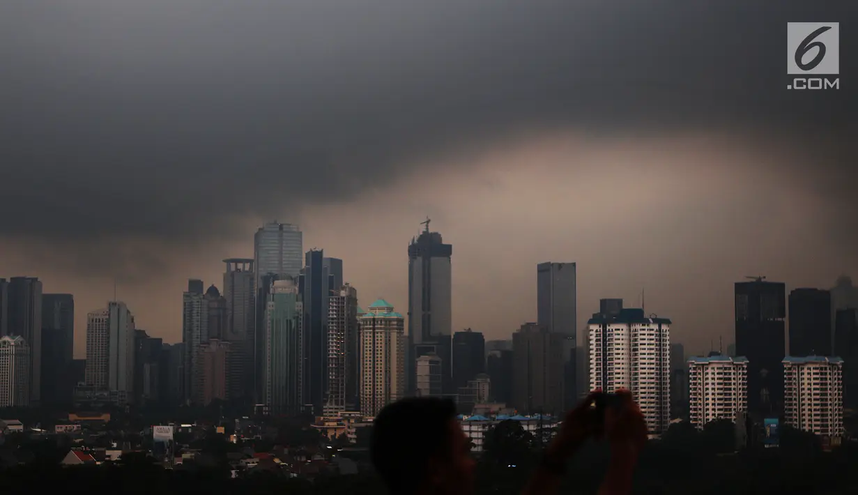 Awan hitam menyelimuti langit Jakarta, Senin (3/12). Badan Meteorologi Klimatologi dan Geofisika (BMKG) memprediksi Jakarta akan selalu diguyur hujan hingga awal tahun 2019. (Liputan6.com/JohanTallo)