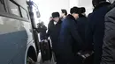 Rombongan grup orkestra Korut masuk ke dalam bus saat tiba di kantor transit Korea di DMZ yang membagi kedua Korea di Paju (5/2). 140 anggota orkestra Korut akan tampil pada perhelatan Olimpiade Musim Dingin 2018. (AFP Photo/Pool/Jung Yeon-Je)