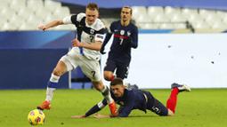 Pemain Prancis, Clement Lenglet, terjatuh saat berebut bola dengan pemain Finlandia, Rasmus Karjalainen, pada laga uji coba di Stadion Stade de France, Rabu (11/11/2020). Prancis takluk dengan skor 0-2. (AP/Michel Euler)