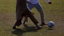 Pengungsi Afghanistan bermain sepak bola di taman bermain Institut Pengembangan Sumber Daya Manusia Nasional di Jincheon, Korea Selatan (13/10/2021). Sekitar 390 warga Afghanistan diterbangkan dari Kabul ke Korea Selatan. (AFP/Pool/Jeon Heon-kyun)