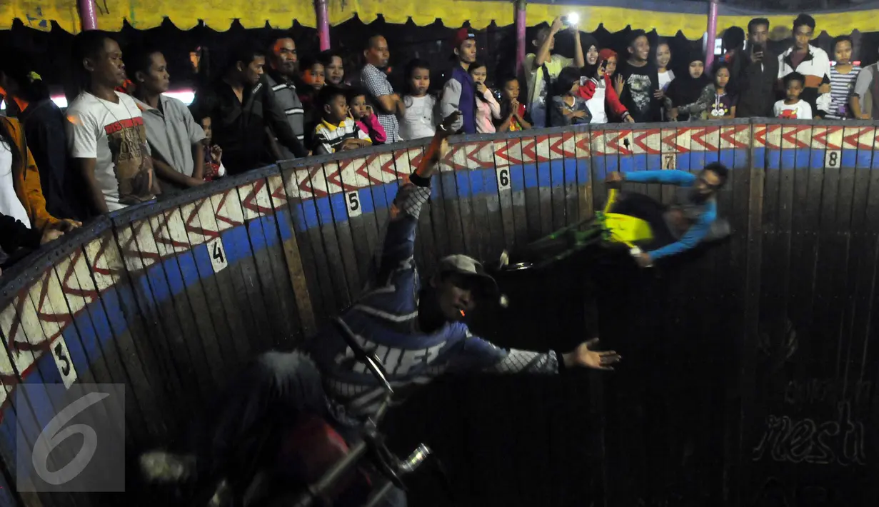 Pengunjung saat melihat atraksi 'Tong setan' di pasar malam PURI BETA II, Tangerang , Banten, Kamis (31/12). Untuk menonton pertunjukan ini di kenakan biaya 7000 sekali masuk tong setan. (Liputan6.com/Helmi Afandi)