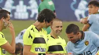 Kapten dan gelandang Beitar Jerusalem, Idan Vered (kanan) memeriksa jari-jari terawat wasit sepak bola transgender pertama Israel, Sapir Berman (tengah) sebelum Liga Premier Israel melawan Hapoel Haifa di Stadion Samy Ofer di kota Haifa, Senin (3/5/2021). (JACK GUEZ / AFP)