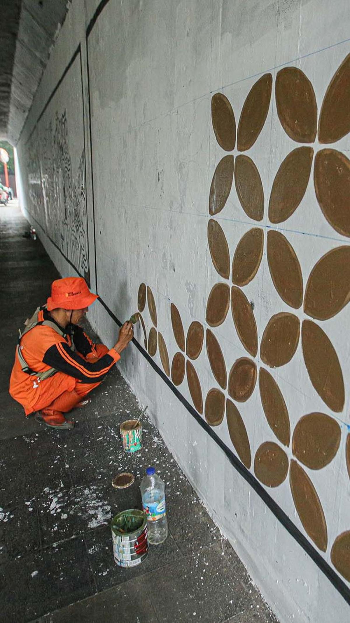 Dalam pengerjaannya, pasukan oranye ini saling berbagi tugas. Ada yang membuat mural, ada juga yang menggambar motif.
