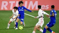 Pemain Real Madrid, Alvaro Odriozola, berebut bola dengan pemain Getafe, Marc Cucurella, pada laga Liga Spanyol di Stadion Alfonso Perez, Senin (19/4/2021). Kedua tim bermain imbang 0-0. (Photo by PIERRE-PHILIPPE MARCOU / AFP)