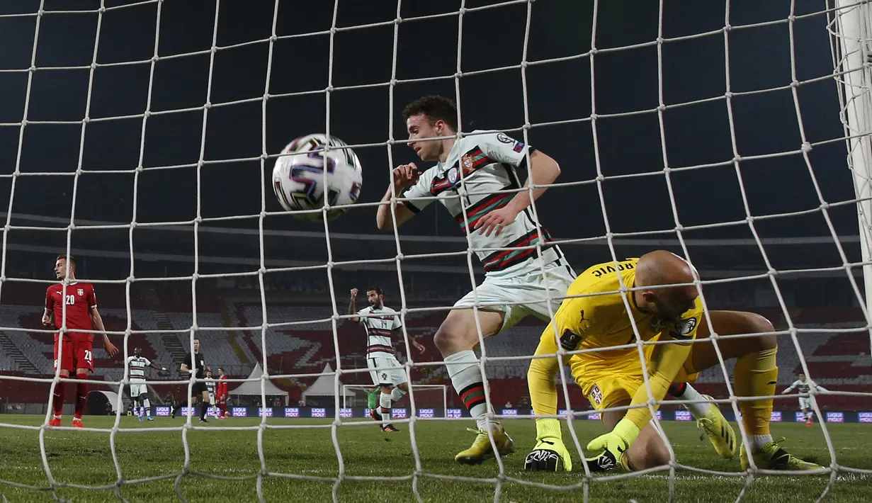 Kiper Serbia, Marko Dmitrovic (kanan) kebobolan gol kedua oleh striker Portugal, Diogo Jota dalam laga Kualifikasi Piala Dunia 2022 Zona Eropa Grup A di Rajko Mitic Stadum, Belgrade, Sabtu (27/3/2021). Serbia bermain imbang 2-2 dengan Portugal. (AFP/Pedja Milosavljevic)