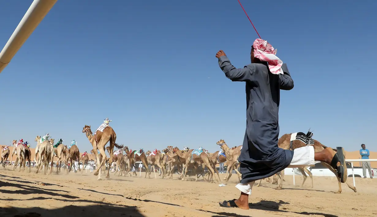 Sejumlah unta berlari kencang saat mengikuti lomba balap Liwa 2018 Moreeb Dune Festival di gurun Liwa, Abu Dhabi (26/12). Keberadaan robot itu ialah perubahan dari perbudakan anak yang menjadi bagian kelam dari budaya balap unta. (AFP Photo/Karim Sahib)
