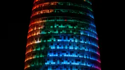 Proyeksi cahaya warna pelangi menerangi gedung pencakar langit Torre Agbar saat peringatan World Pride di Barcelona, Spanyol, 28 Juni 2017. World Pride merupakan acara perayaan LGBT terbesar di dunia yang diadakan setiap tahun. (AP/Manu Fernandez)
