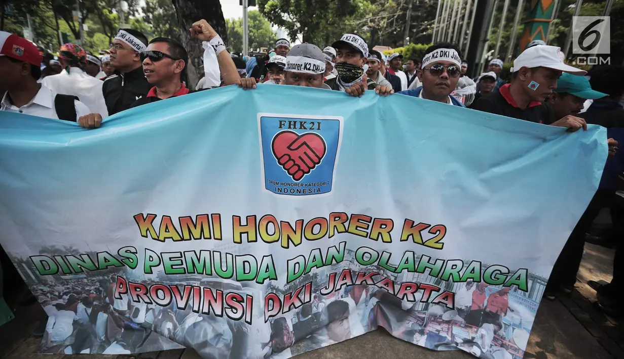 Pegawai honorer DKI Jakarta membawa spanduk bertuliskan aspirasi saat menggelar demo di Balai Kota, Jakarta, Rabu (26/9). Massa tergabung dalam Forum Honorer Kategori 2 Indonesia (FHK2I). (Liputan6.com/Faizal Fanani)