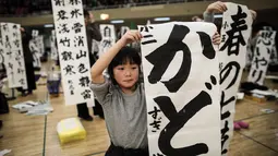 Peserta menunjukkan tulisan Jepang mereka saat mengikuti lomba kaligrafi Tokyo, Jepang (5/1). Lomba kaligrafi tulisan Jepang ini digelar setiap tahun yang diadakan pada awal tahun baru. (AFP Photo/Behrouz Mehri)