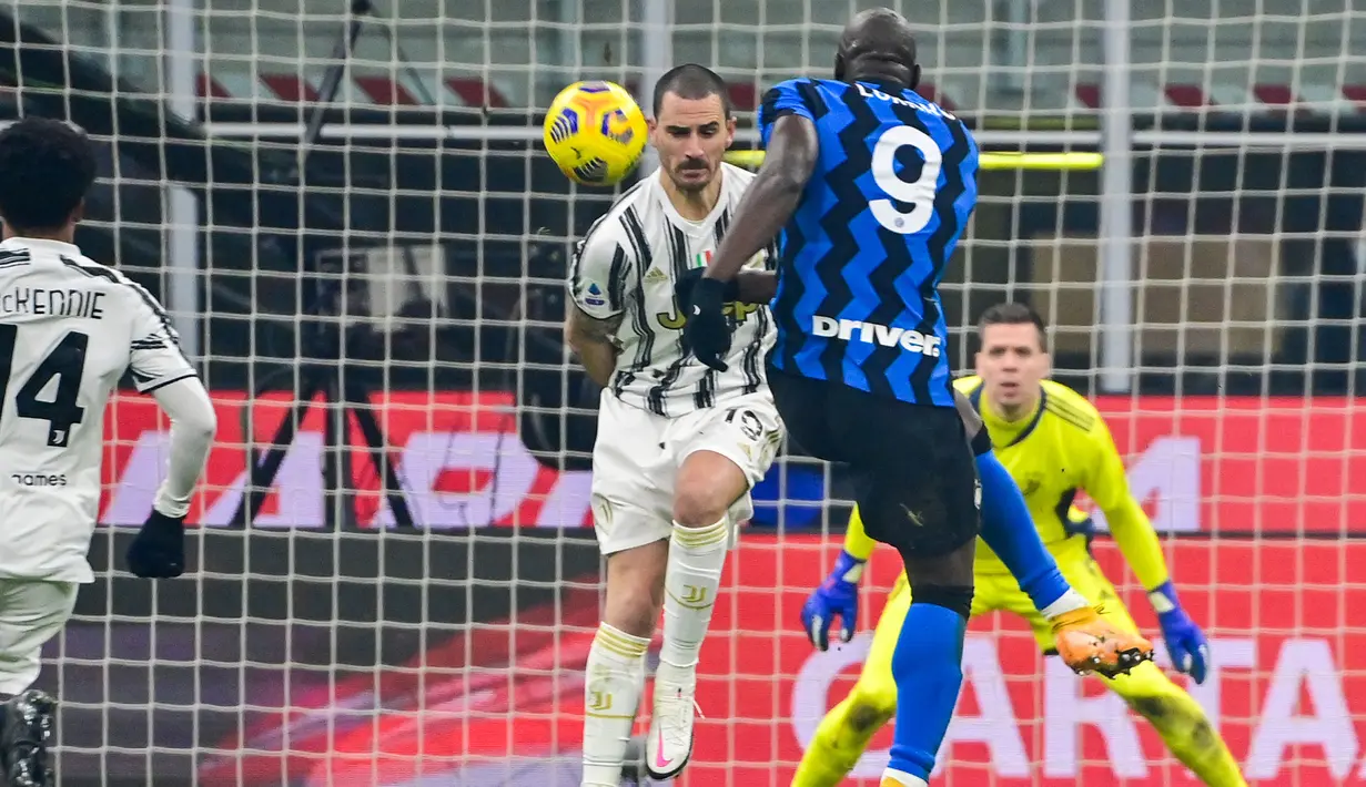 Striker Inter Milan, Romelu Lukaku melepaskan tendangan yang dihalangi bek Juventus, Leonardo Bonucci dalam laga lanjutan Liga Italia Serie A 2020/21 pekan ke-18 di San Siro Stadium, Minggu (17/1/2021). Inter Milan menang 2-0 atas Juventus. (AFP/Miguel Medina)