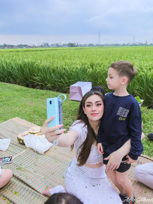 Celine Evangelista, mengajak putranya selfie dengan latar belakang sawah. Lucio terlihat cuek. (Foto: Instagram/@celine_evangelista