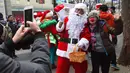 Seorang wanita FOTO bersama Santa Claus saat promosi musim Natal di distrik perbelanjaan di Seoul (13/11). Meski sebagian besar penduduknya adalah umat Budha, anak muda Korsel menikmati perayaan musim Natal tersebut. (AFP Photo/Jung Yeon-Je)