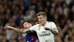 Pemain Real Madrid, Toni Kroos berebut bola dengan penyerang Barcelona, Lionel Messi pada laga leg kedua semifinal Copa del Rey di Stadion Santiago Bernabeu, Rabu (27/2). Barcelona merebut tiket final Copa del Rey usai menang 3-0. (AP/ Manu Fernandez)