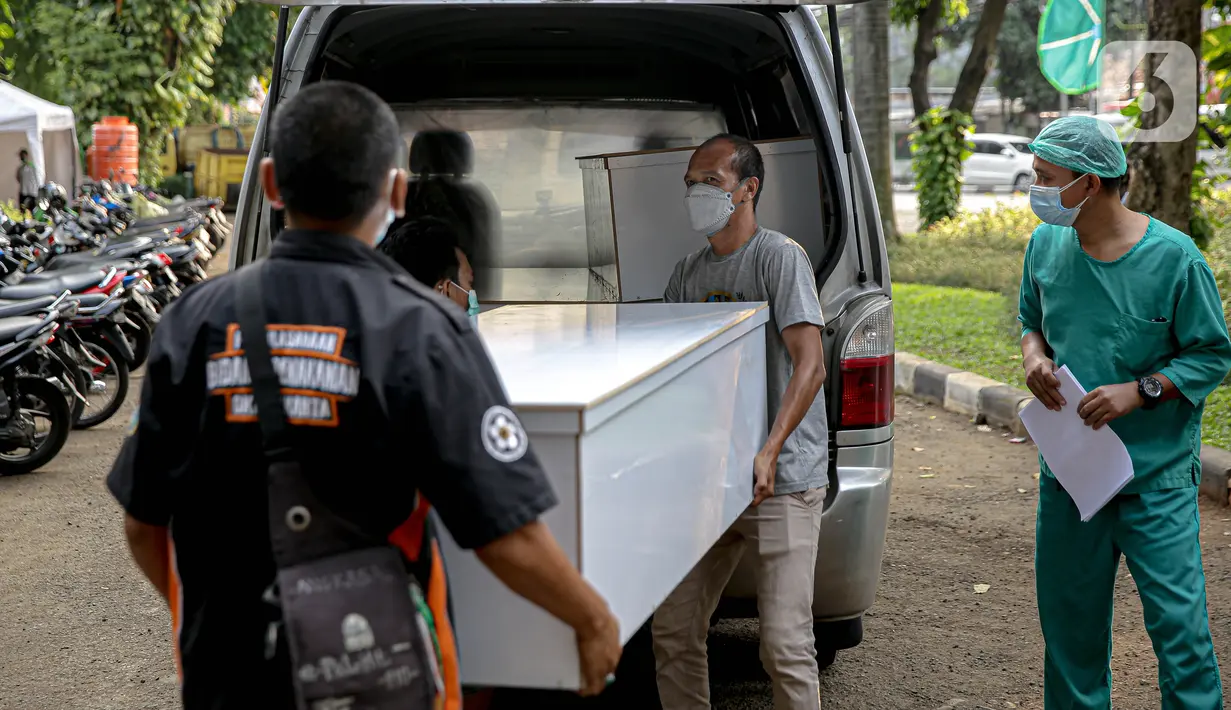 Petugas memindahkan peti jenazah COVID-19 untuk didistribusikan ke rumah sakit di TPU Petamburan, Jakarta, Selasa (6/7/2021). Dalam sehari, 100-200 peti jenazah didistribusikan ke sejumlah rumah sakit di DKI Jakarta. (Liputan6.com/Faizal Fanani)