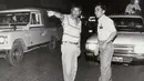 Gambar yang diambil pada awal 1990-an memperlihatkan Rodrigo Duterte (kiri) yang masih menjabat sebagai Wali Kota Davao, membantu seorang polisi untuk mengatur kemacetan lalu lintas di jalanan pusat kota Davao, Filipina selatan. (REUTERS/Renato Lumawag)