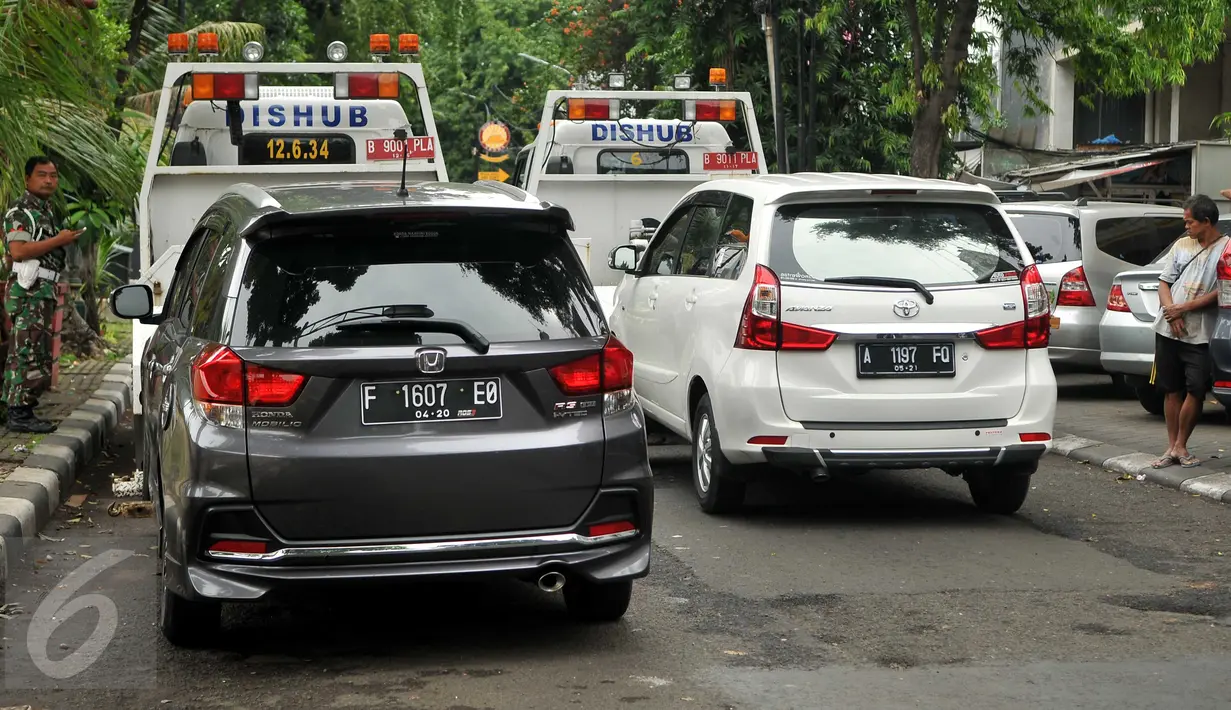 Dua mobil pribadi yang parkir liar diderek petugas Dishub DKI di kawasan Pasar Baru, Jakarta, Senin (27/6). Penertiban rutin ini dilakukan untuk menciptakan kawasan yang tertib serta nyaman. (Liputan6.com/Gempur M Surya)