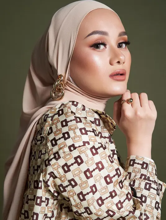 Outfit netral ini dipadukan dengan hijab lilit dan makeup bold latte yang glowing [@winstongomez]