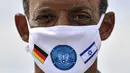 Letnan Kolonel Jerman Samuel Mbassa memakai masker dengan bendera Israel dan Jerman di pangkalan udara, Noervenich, Jerman, Kamis (20/8/ 2020. Pilot Israel dan Jerman akan terbang bersama selama dua minggu ke depan selama latihan Angkatan Udara gabungan pertama di Jerman. (AP Photo/Martin Meissner)