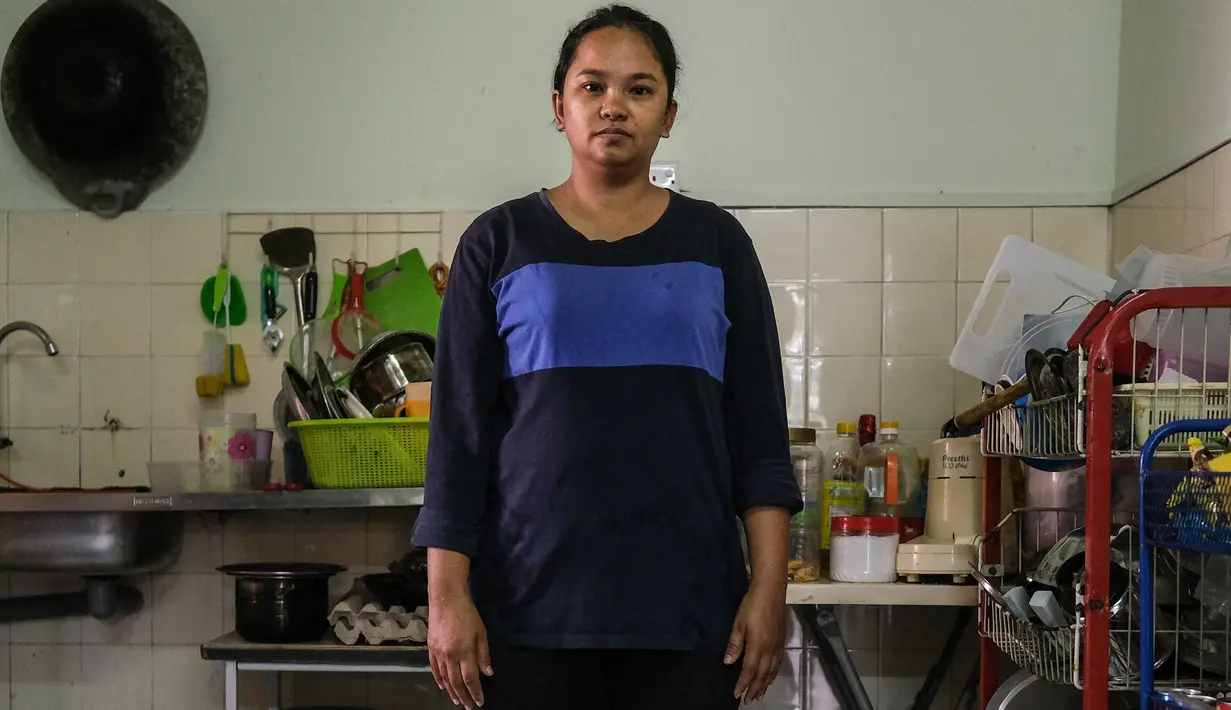 Ibu tunggal Tilda Kalaivani berpose di apartemen sewaannya di Kuala Lumpur pada 6 Juli 2021. Ketika Malaysia memerangi pandemi corona yang memburuk, semakin banyak keluarga berpenghasilan rendah yang berjuang dalam lockdown ketat mengibarkan bendera putih untuk memohon bantuan. (Mohd RASFAN/AFP)