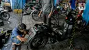 Montir memperbaiki sepeda motor konsumen usai terendam banjir di kawasan Mampang, Jakarta, Minggu (21/2/2021). Banjir yang melanda Ibu Kota Jakarta pada Sabtu (20/2) menyebabkan banyak kendaraan warga mengalami kerusakan akibat terendam air. (Liputan6.com/Faizal Fanani)