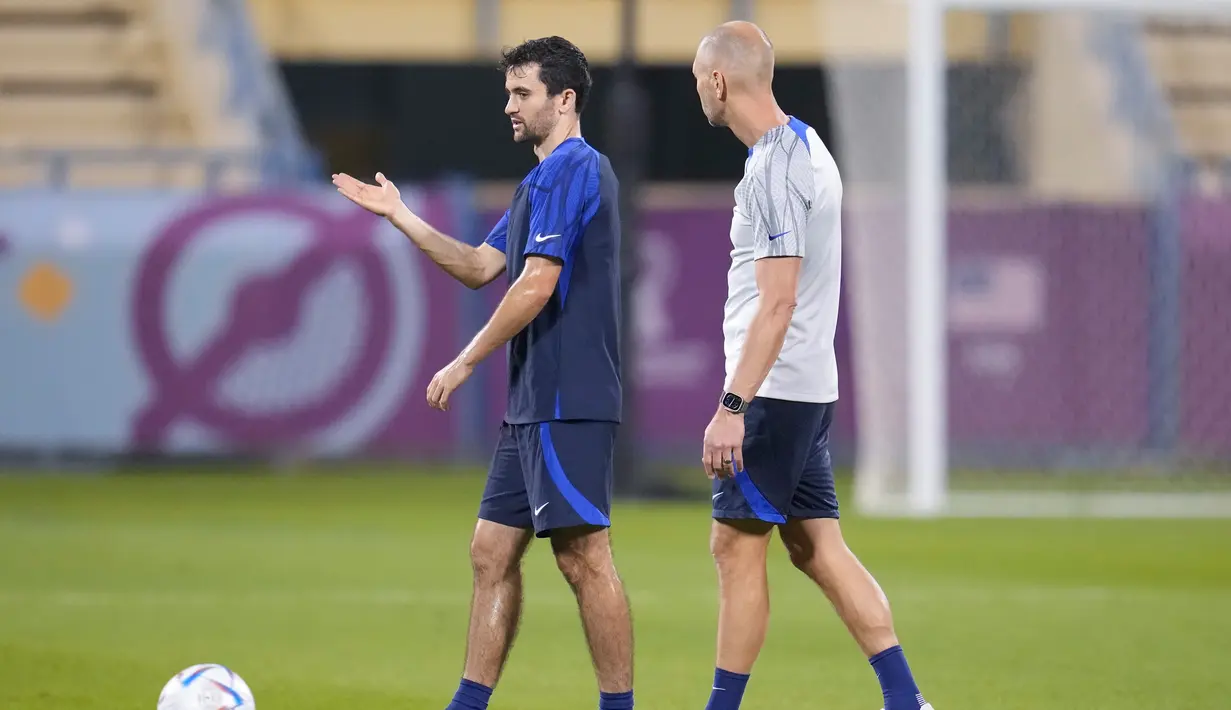 Luca de la Torre (kiri) berbicara dengan pelatih kepala pelatih Gregg Berhalter selama sesi latihan resmi di Stadion Al-Gharafa SC, Doha, Senin (28/11/2022). Akibat kegaduhan ini Gregg Berhalter meminta maaf atas keriuhan yang sudah terjadi dan menegaskan timnas AS hanya akan fokus pada sepakbola. (AP Photo/Ashley Landis)