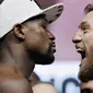 Petarung MMA, Conor McGregor dan petinju Floyd Mayweather Jr saat sesi timbang berat badan di Las Vegas, Jumat (25/8/2017). Keduanya akan bertarung pada Minggu (27/6/2017) di T-Mobile Arena, Las Vegas, Amerika Serikat. (AP/John Locher)