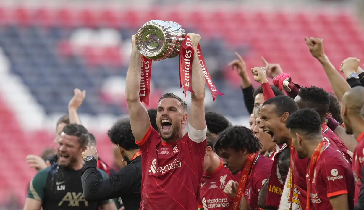 <p>Gelandang Liverpool Jordan Henderson mengangkat trofi Piala FA 2021/2022 dan berselebrasi setelah memenangkan partai final atas Chelsea di Stadion Wembley pada Minggu (16/5/2022) dini hari WIB. Liverpool sukses menjuarai Piala FA 2021/2022 mengalahkan Chelsea lewat adu penalti. (AP Photo/Kirsty Wigglesworth)</p>