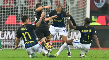 Gelandang AC Milan, Giacomo Bonaventura (tengah) berusaha melewati tiga pemain Inter Milan pada laga Liga Italia Serie A di Stadion San Siro, Milan, (20/11). AC Milan bermain imbang dengan Inter Milan dengan skor 2-2. (AFP PHOTO/Guiseppe Cacace)