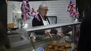 Seorang perempuan menjual pai di pasar di pusat kota London, Jumat, 5 Mei 2023. Penobatan Raja Charles III akan berlangsung di Westminster Abbey pada 6 Mei. (AP Photo/Peter Dejong)