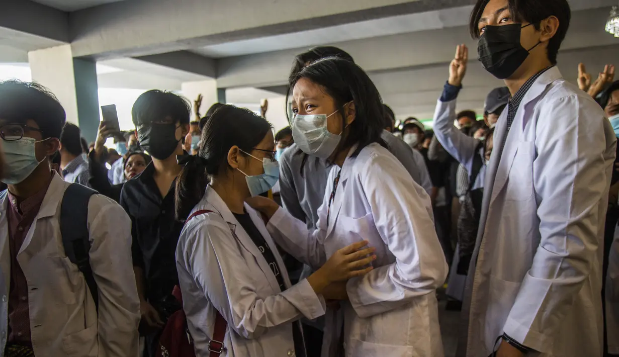 Mahasiswa kedokteran berduka ketika yang lain memberi hormat tiga jari selama pemakaman Khant Ngar Hein di Yangon, Myanmar, Selasa (16/3/2021). Khant Ngar Hein, mahasiswa kedokteran berusia 18 tahun ditembak di dadanya di Tamwe, Yangon oleh pasukan keamanan selama protes anti-militer. (AP Photo)