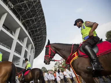 Polisi berkuda mengikuti apel besar persiapan Asian Games di sekitar SUGBK, Jakarta, Senin (4/6/2018). Pembukaan Asian Games XVII Jakarta-Palembang akan digelar pada 18 Agustus 2018 mendatang. (Bola.com/Vitalis Yogi Trisna)