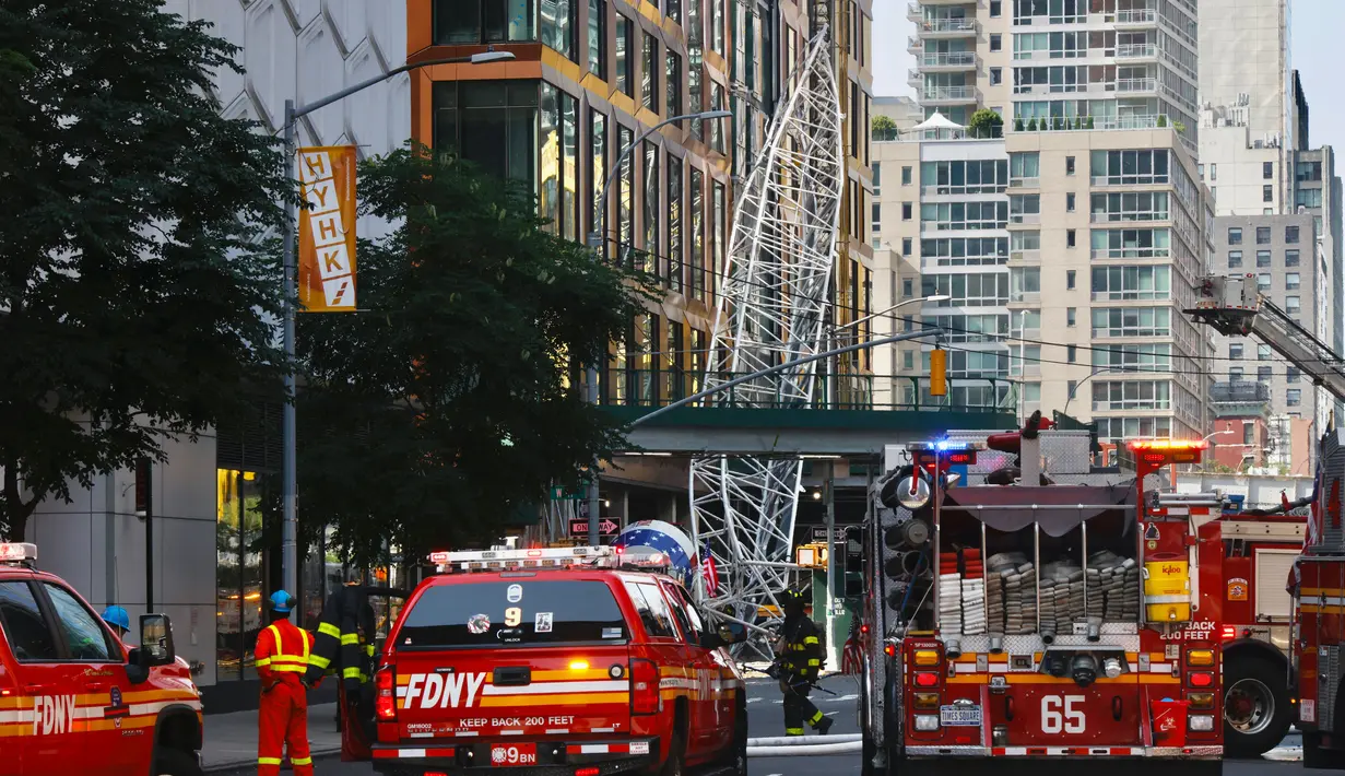 Crane itu kemudian jatuh menghantam sebuah bangunan di seberang jalan. (Kena Betancur / AFP)