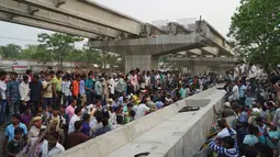 Warga India berusaha menyelamatkan korban yang terperangkap akibat runtuhnya jalan layang di Varanasi, Selasa (15/5). Material jalan layang yang memiliki berat berton-ton itu menimpa dan menghancurkan sejumlah kendaraan di bawahnya. (AP Photo)