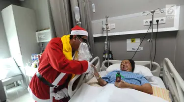 Seorang pria mengenakan kostum Santa Claus membagikan bingkisan Natal kepada pasien yang dirawat di RS Siloam, TB Simatupang, Jakarta, Kamis (21/12). Kegiatan ini dalam rangka menyambut perayaan Hari Natal 2017. (Liputan6.com/Joan)