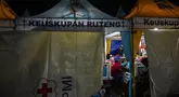 Kerabat menyaksikan para korban gempa bumi mendapatkan perawatan di tenda medis darurat di depan Rumah Sakit Ruteng di Ruteng, Manggarai, Nusa Tenggara Timur, Sabtu malam, 15 Agustus 2025. (AFP/ Juni Kriswanto)