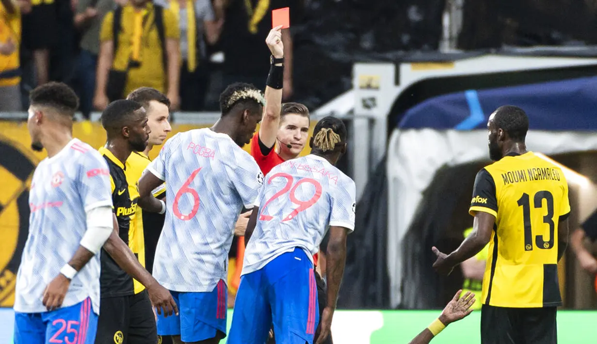 Wasit Francois Letexier (tengah) menunjukkan kartu merah kepada pemain Manchester United Aaron Wan-Bissaka (29) saat melawan Young Boys pada pertandingan Grup F Liga Champions di Stadion Wankdorf, Bern, Swiss, Selasa (14/9/2021). Young Boys menang 2-1. (Alessandro della Valle/Keystone via AP)