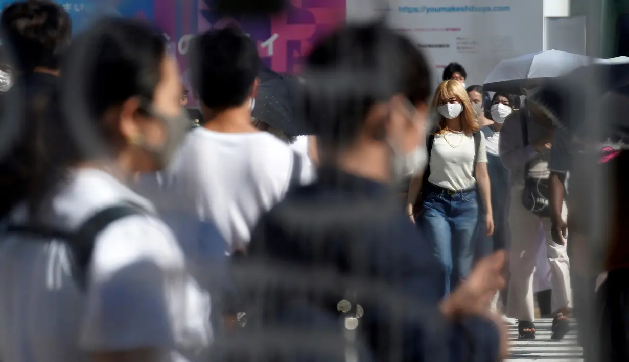 Orang-orang yang memakai masker untuk mencegah penyebaran COVID-19 meyeberang jalan di Shibuya, Tokyo, Jepang, Jumat (3/7/2020). Jepang mengangkat darurat pandemi selama tujuh minggu pada akhir Mei, sebagian besar kegiatan sosial dan bisnis sejak itu telah kembali dimulai. (AP Photo/Eugene Hoshiko)