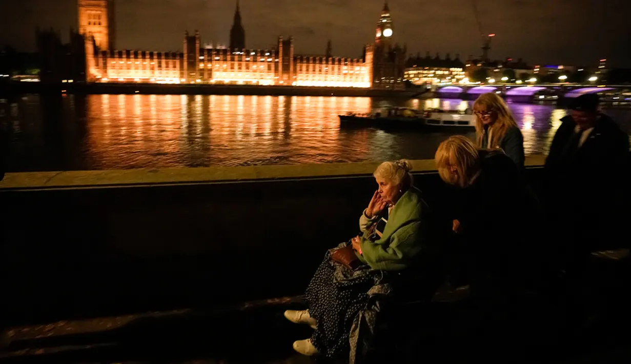Seorang wanita tua duduk di kursi roda saat antre untuk memberikan penghormatan kepada mendiang Ratu Elizabeth II di London, Inggris, 15 September 2022. Antrean pelayat sudah mengular mulai dari Parlemen, melintasi Jembatan Lambeth di dekatnya dan di sepanjang tepi seberang Sungai Thames. (AP Photo/Andreea Alexandru)